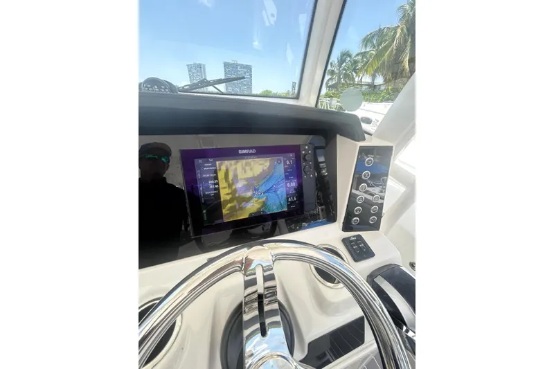 Slide: The Image of 2021 Robalo R302 Center Console helm with Simrad display and steering wheel. - 11