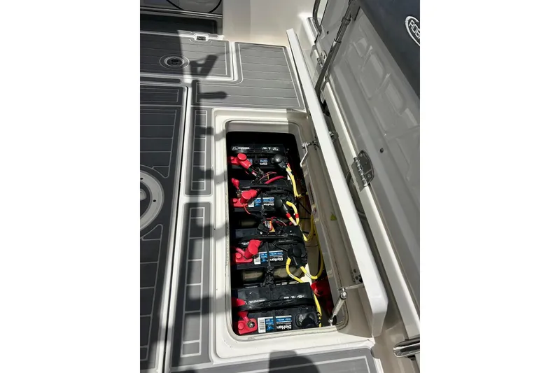 Slide: The Image of 2021 Robalo R302 Center Console boat battery compartment with multiple batteries visible. - 17