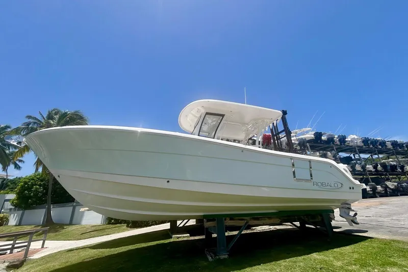 Slide: The Image of 2021 Robalo R302 Center Console boat on display under clear blue sky. - 7