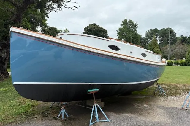 The Image of 1981 Mark O Atlantic City 24 sailboat on stands, blue hull, white deck, outdoors. - 1
