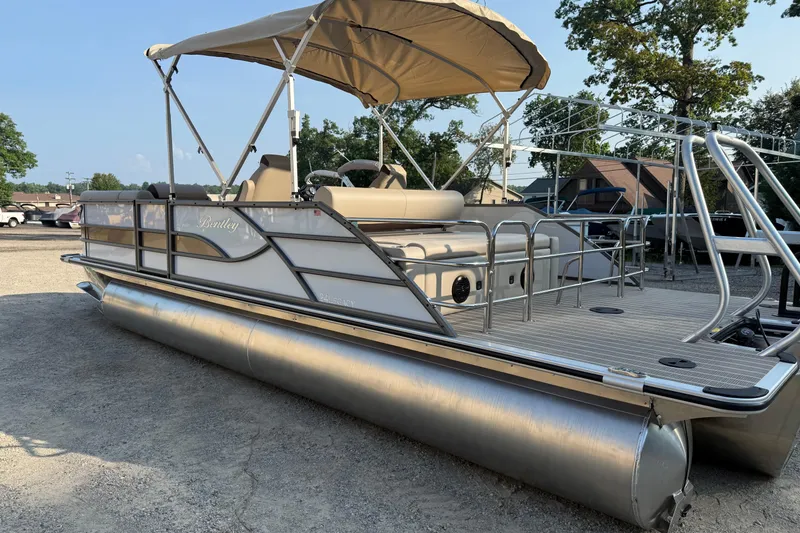 Slide: The Image of 2026 Bentley Pontoons Legacy 243 Swingback EXT with canopy, parked outdoors. - 10