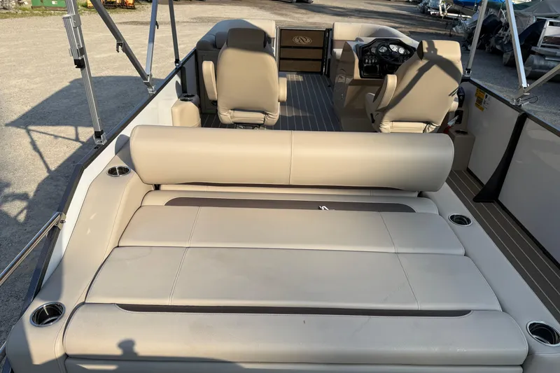 Slide: The Image of 2026 Bentley Pontoons Legacy 243 Swingback EXT interior with beige seating and modern dashboard. - 11