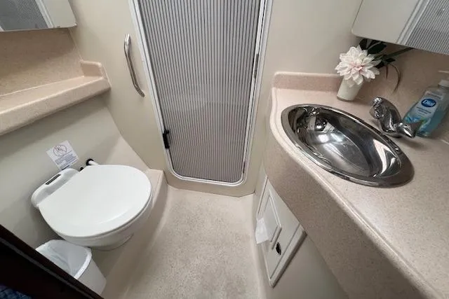 Slide: The Image of Bathroom interior of 2003 Catalina 470 Sloop, featuring sink, toilet, and shower area. - 27