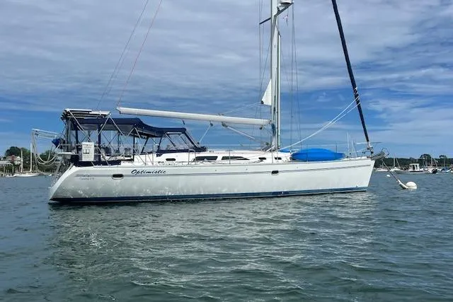 Slide: The Image of 2003 Catalina 470 Sloop with Wing Keel sailing on calm waters under a cloudy sky. - 44