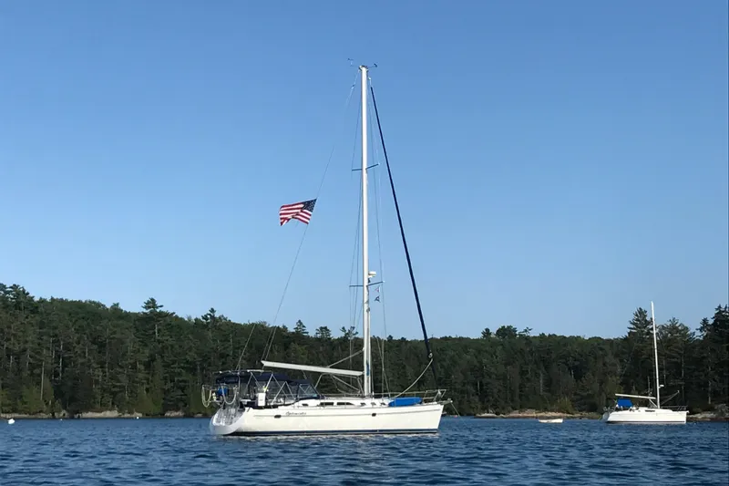 Slide: The Image of 2003 Catalina 470 Sloop with wing keel sailing on a calm lake under clear skies. - 46