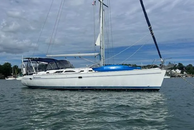 Slide: The Image of 2003 Catalina 470 Sloop with Wing Keel sailing on calm waters under cloudy skies. - 47