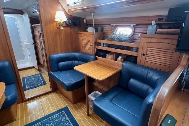 Slide: The Image of Interior of 2003 Catalina 470 Sloop, featuring cozy seating and wooden cabinetry. - 6