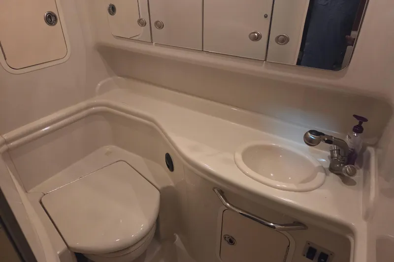 Slide: The Image of 2007 Sea Ray 320 Sundancer bathroom with sink, toilet, and storage cabinets. - 19