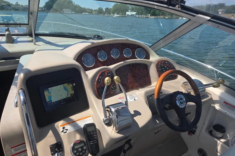 Slide: The Image of 2007 Sea Ray 320 Sundancer helm with navigation system and steering wheel on a sunny day. - 3