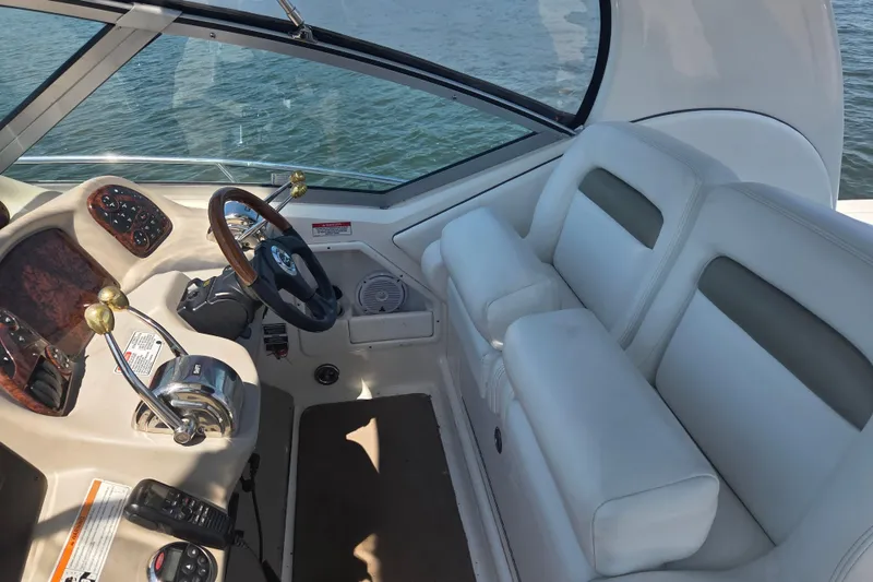 Slide: The Image of 2007 Sea Ray 320 Sundancer helm with steering wheel and plush seating, overlooking water. - 5