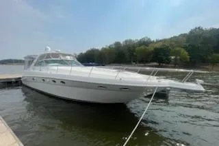 Slide: The Image of 2003 Sea Ray Sundancer 460 yacht docked on a calm lake with trees in the background. - 2