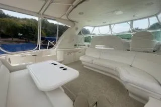 Slide: The Image of 2003 Sea Ray Sundancer 460 yacht interior with white seating and table, featuring large windows. - 21