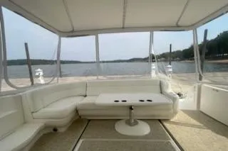 Slide: The Image of 2003 Sea Ray Sundancer 460 yacht interior with white seating and table, overlooking serene waters. - 23