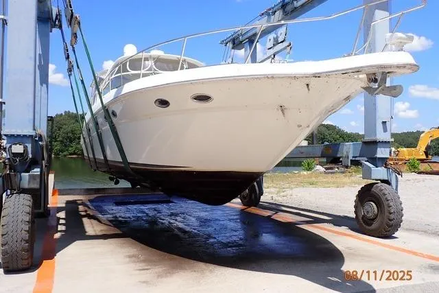 Slide: The Image of 2003 Sea Ray Sundancer 460 yacht being lifted by a boat hoist on a sunny day. - 3