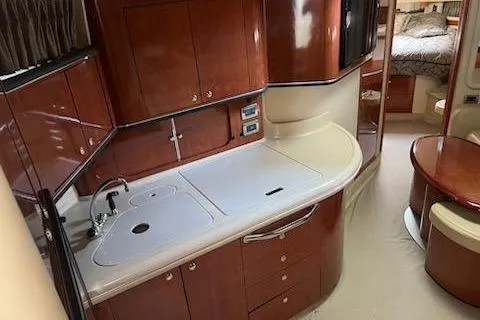 Slide: The Image of 2003 Sea Ray Sundancer 460 yacht interior with elegant wood cabinetry and modern kitchen amenities. - 32