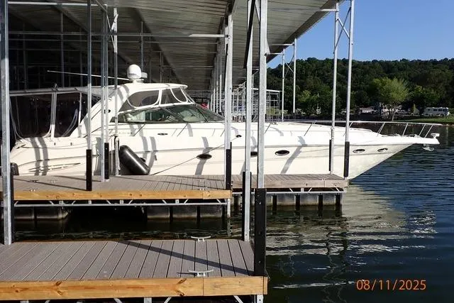 Slide: The Image of 2003 Sea Ray Sundancer 460 yacht docked at marina, surrounded by calm water and greenery. - 6