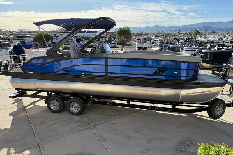 Slide: The Image of 2026 Bennington 26 MCSB pontoon boat on trailer, parked outdoors. - 3
