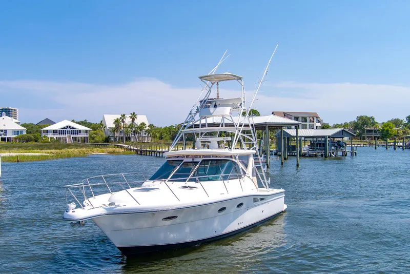 The Image of 2008 Tiara Sport Fish boat on water near docks and waterfront homes. - 0
