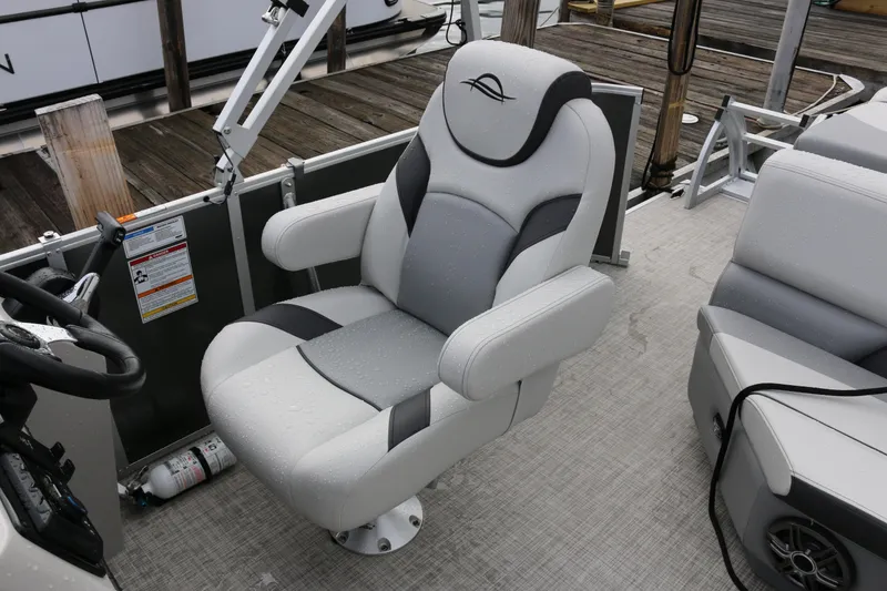 Slide: The Image of Captain's chair on 2025 SunCatcher Select 18C pontoon boat, docked with wet upholstery. - 13