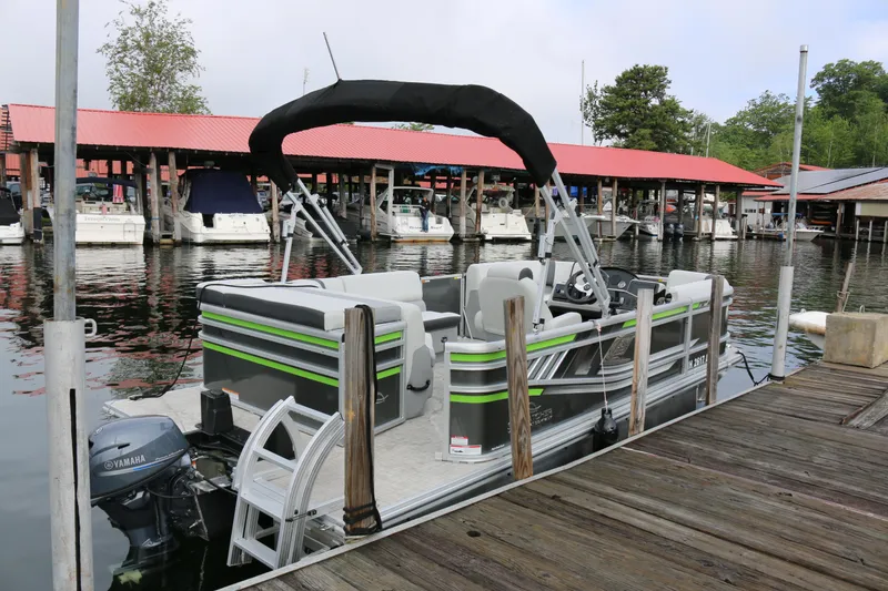 Slide: The Image of 2025 SunCatcher Select 18C pontoon boat docked at marina with Yamaha motor. - 2