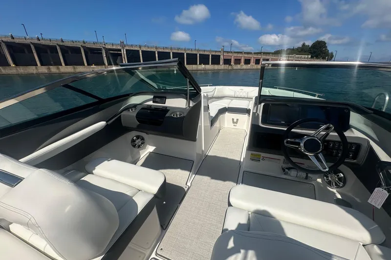 Slide: The Image of 2025 Regal LS4 boat interior with white seating, docked by the water. - 4