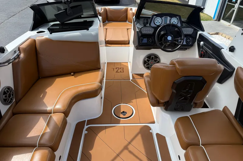 Slide: The Image of 2021 Axis T23 boat interior with brown leather seats and modern dashboard. - 12