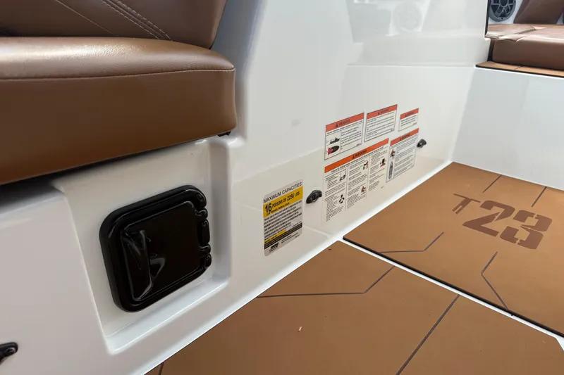 Slide: The Image of Interior of 2021 Axis T23 boat with brown seating and safety instructions. - 19