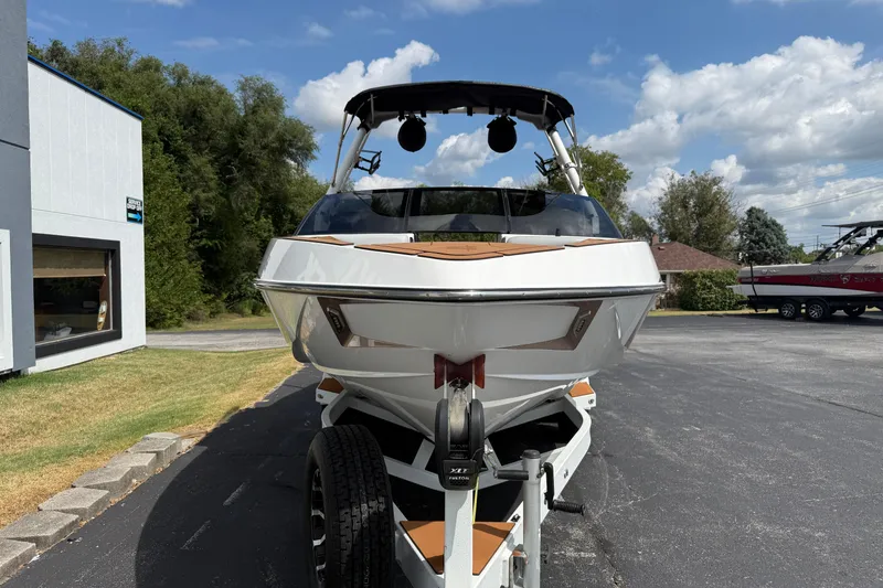 Slide: The Image of 2021 Axis T23 boat on trailer, parked outdoors under a clear blue sky. - 2