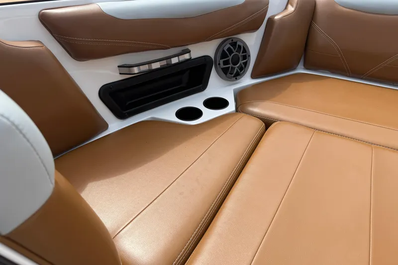 Slide: The Image of 2021 Axis T23 boat interior with tan leather seats, speaker, and cup holders. - 22