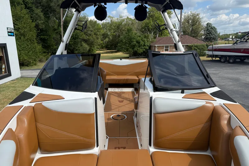 Slide: The Image of 2021 Axis T23 boat interior with tan and white seating, parked outdoors. - 24