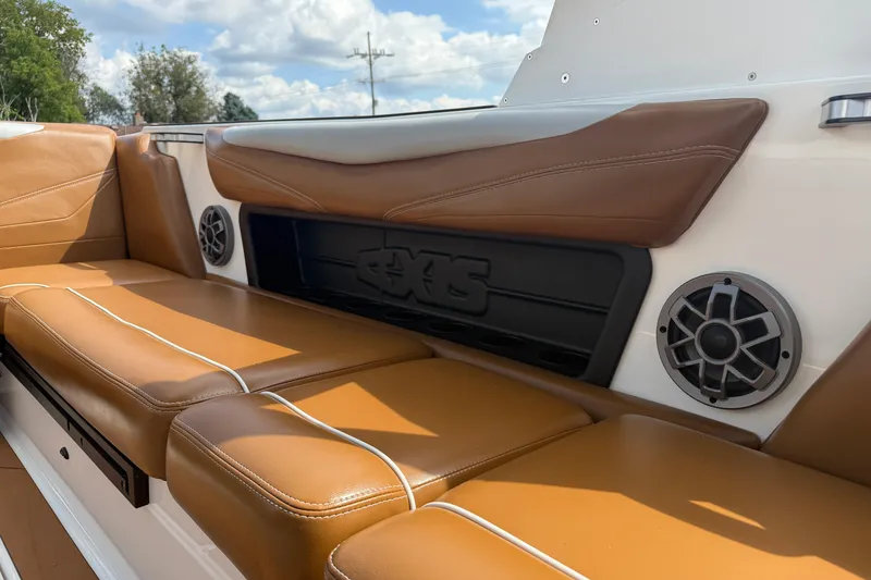 Slide: The Image of 2021 Axis T23 boat interior with brown leather seats and built-in speakers. - 31