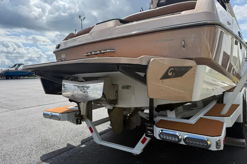 Slide: The Image of 2021 Axis T23 boat rear view with Surf Gate technology, parked on a trailer. - 6
