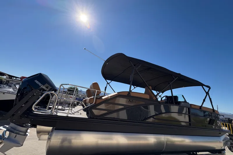 Slide: The Image of 2026 Bennington 24 MSL pontoon boat with powerful outboard motor, parked outdoors. - 3