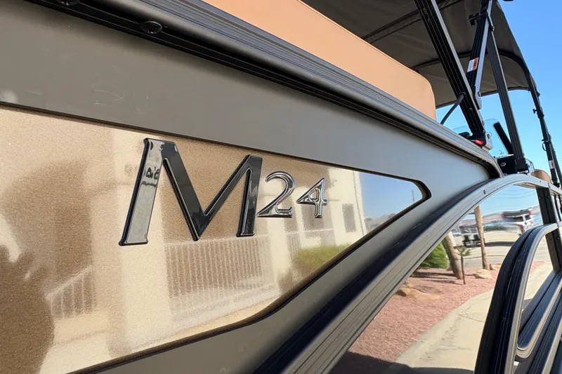 Slide: The Image of 2026 Bennington 24 MSL pontoon boat with powerful outboard motor, docked outdoors. - 6