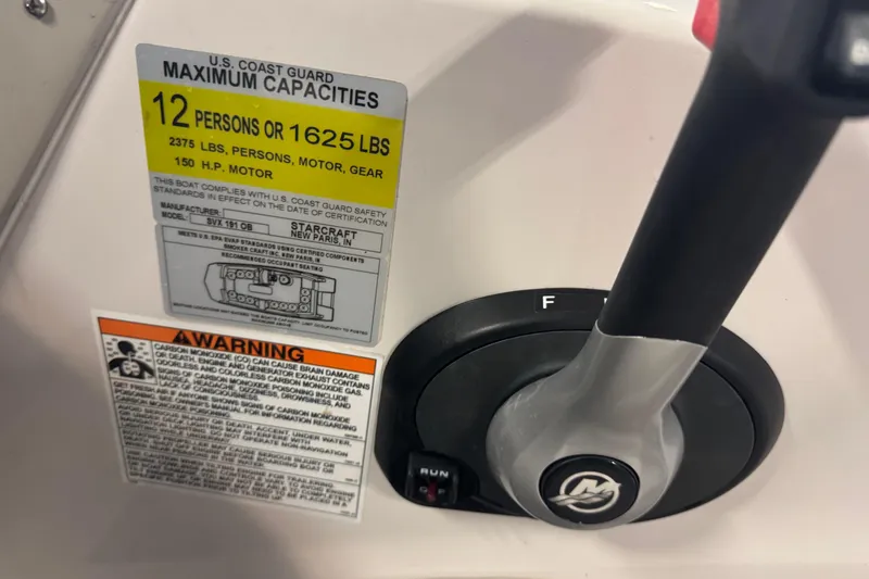 Slide: The Image of 2023 Starcraft SVX 191 OB boat capacity and warning labels near control lever. - 12