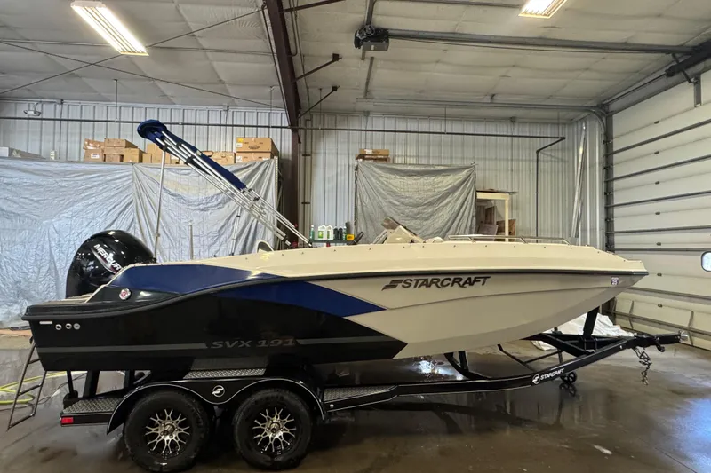 Slide: The Image of 2023 Starcraft SVX 191 OB boat in a garage, on a trailer. - 2