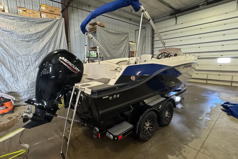Slide: The Image of 2023 Starcraft SVX 191 OB boat with Mercury outboard motor in a garage setting. - 3