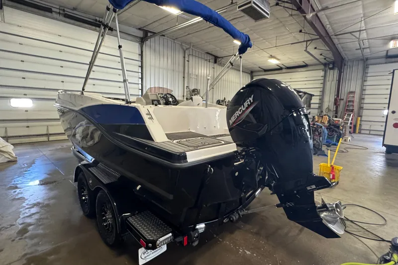 Slide: The Image of 2023 Starcraft SVX 191 OB boat with Mercury outboard motor in a garage. - 4