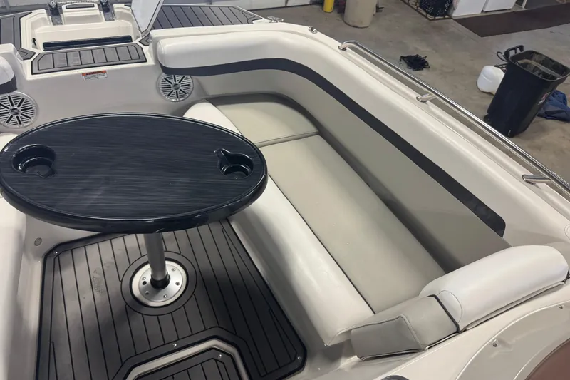 Slide: The Image of 2023 Starcraft SVX 191 OB boat interior with seating and table in a garage setting. - 5