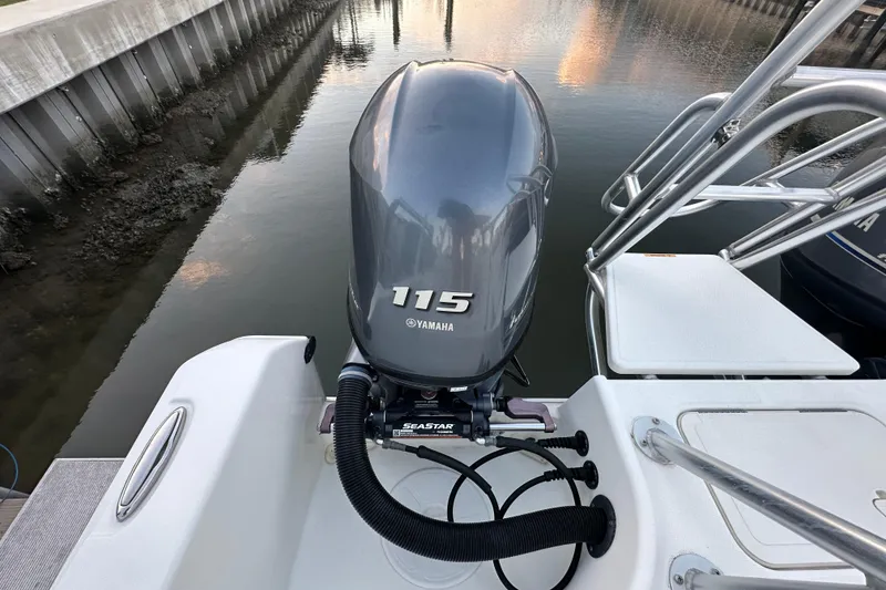 Slide: The Image of Yamaha 115 outboard motor on 2021 World Cat 230 SD boat, docked by water. - 106