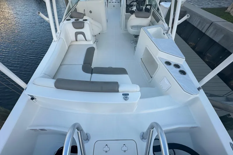 Slide: The Image of 2021 World Cat 230 SD boat interior with seating and helm, docked by the water. - 11