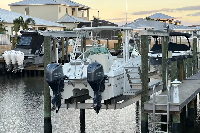 Slide: The Image of 2021 World Cat 230 SD boat docked with dual Yamaha engines in a marina setting. - 114