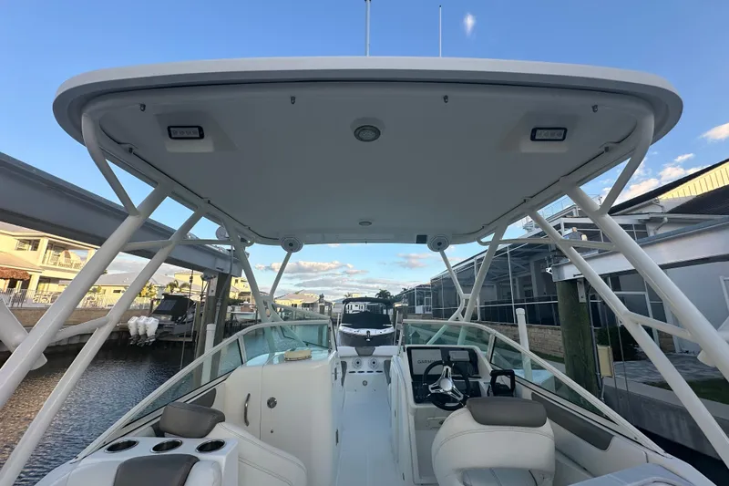 Slide: The Image of 2021 World Cat 230 SD boat interior with helm and seating, docked at marina. - 12