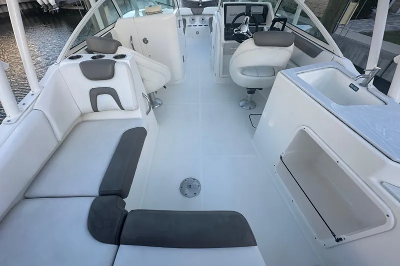 Slide: The Image of 2021 World Cat 230 SD boat interior with seating, helm, and sink. - 14
