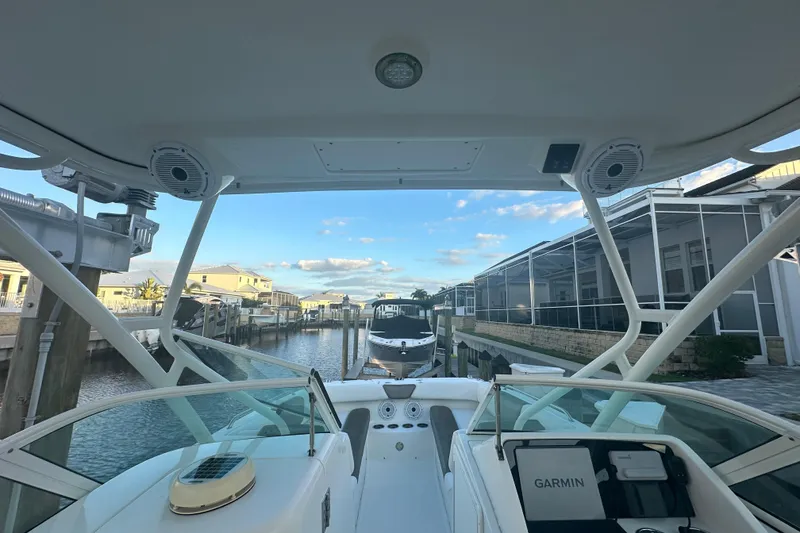 Slide: The Image of 2021 World Cat 230 SD boat docked in a canal with clear blue sky. - 15
