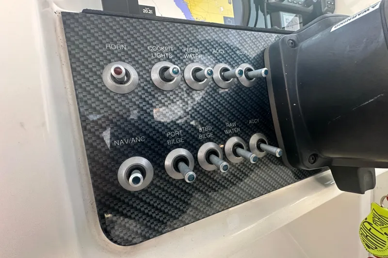 Slide: The Image of Control panel of a 2021 World Cat 230 SD boat with labeled switches. - 25