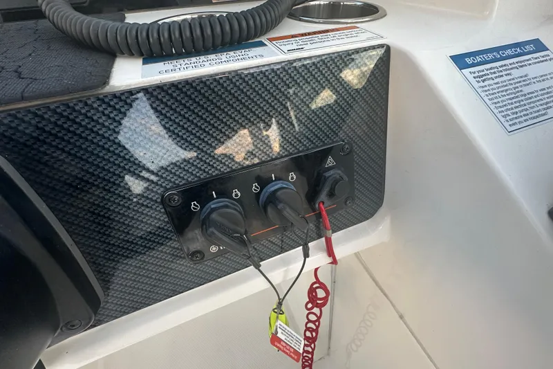 Slide: The Image of Control panel of a 2021 World Cat 230 SD boat with switches and safety lanyard. - 26