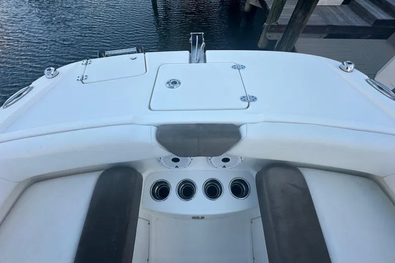 Slide: The Image of 2021 World Cat 230 SD boat interior with seating and cup holders, docked by the water. - 37