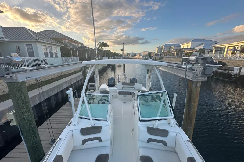 Slide: The Image of 2021 World Cat 230 SD boat docked in a scenic waterfront neighborhood at sunset. - 40
