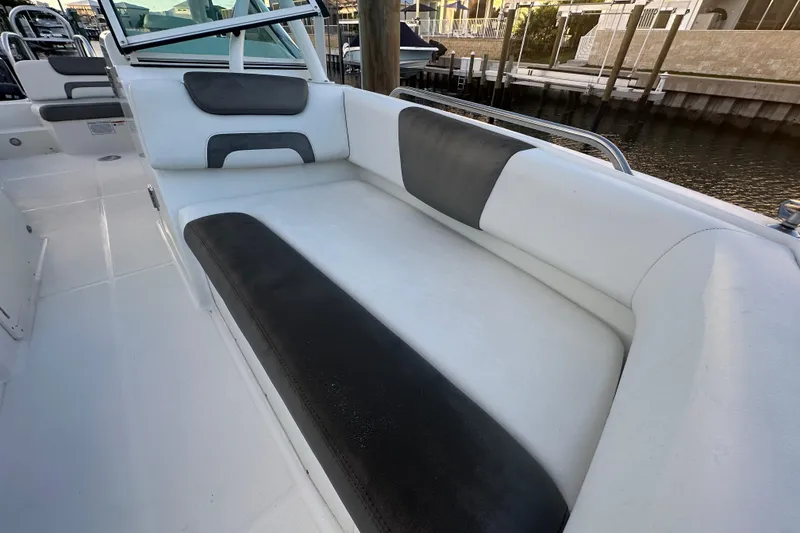 Slide: The Image of 2021 World Cat 230 SD boat interior with cushioned seating by the water. - 44